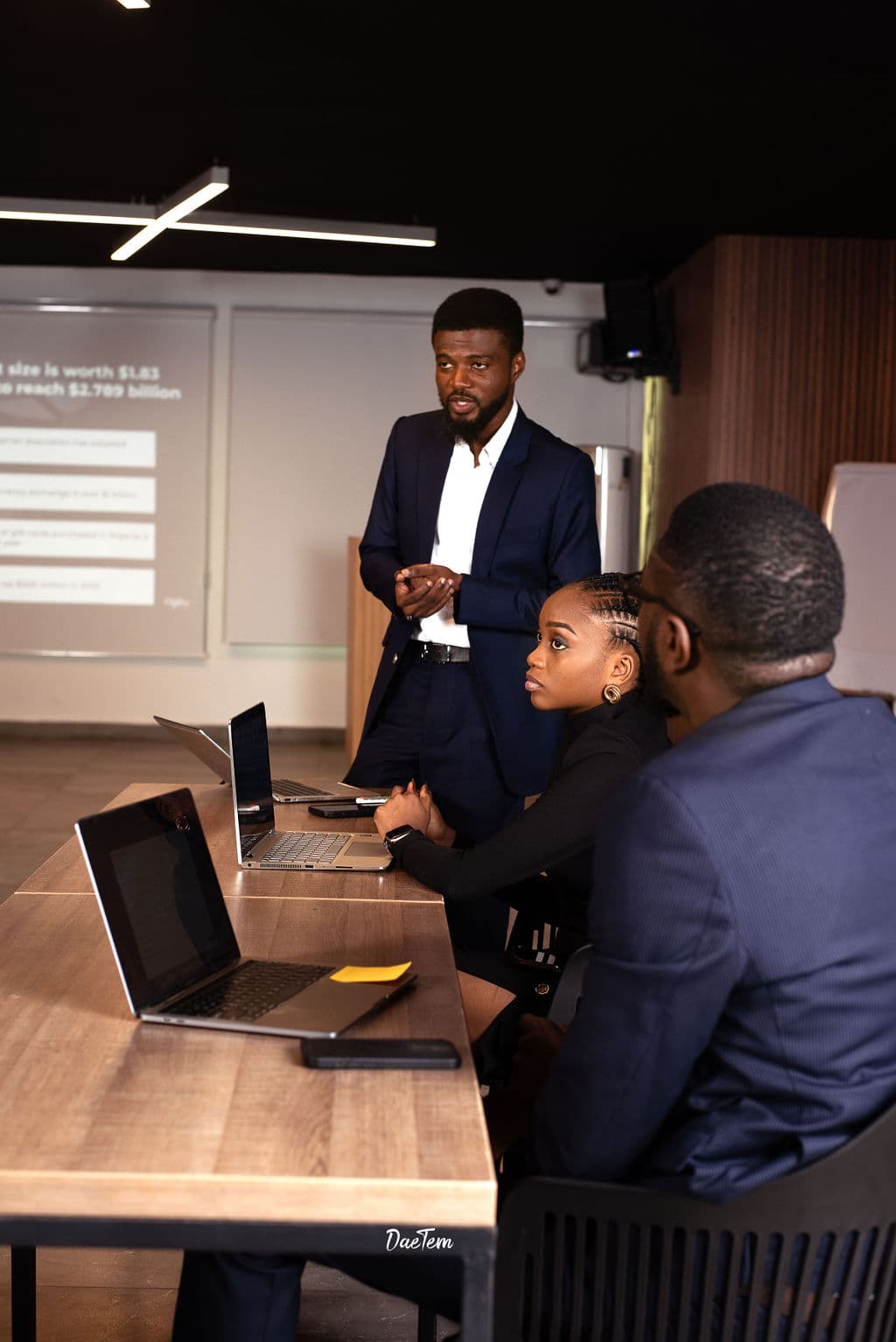 ’Joba presenting to a team in a meeting room